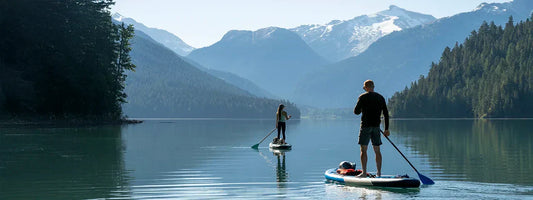 Couple stand up paddling on a lake, representing active lifestyles supported by Supple joint health supplements with glucosamine, chondroitin, and boswellia.
