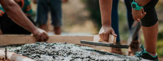 A woman laying concrete wearing a watch