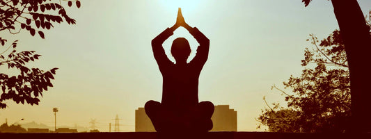A woman silhouette meditating with arms raised and the sun behind her, representing active lifestyles supported by Supple joint health supplements with glucosamine, chondroitin, and boswellia.