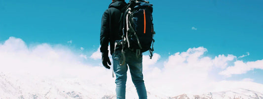 A man with a travel bag looking out at the top of a mountain, representing active lifestyles supported by Supple joint health supplements with glucosamine, chondroitin, and boswellia.