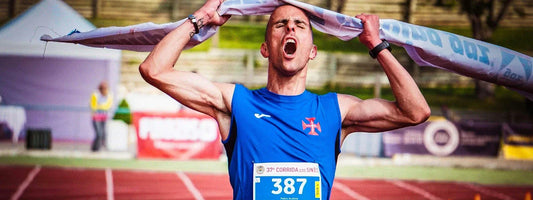 A man holding up a banner in relief after running a marathon, representing active lifestyles supported by Supple joint health supplements with glucosamine, chondroitin, and boswellia.