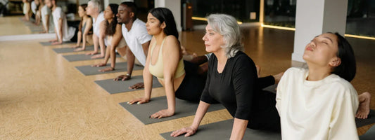 A group of men and woman stretching on yoga mats, representing active lifestyles supported by Supple joint health supplements with glucosamine, chondroitin, and boswellia.